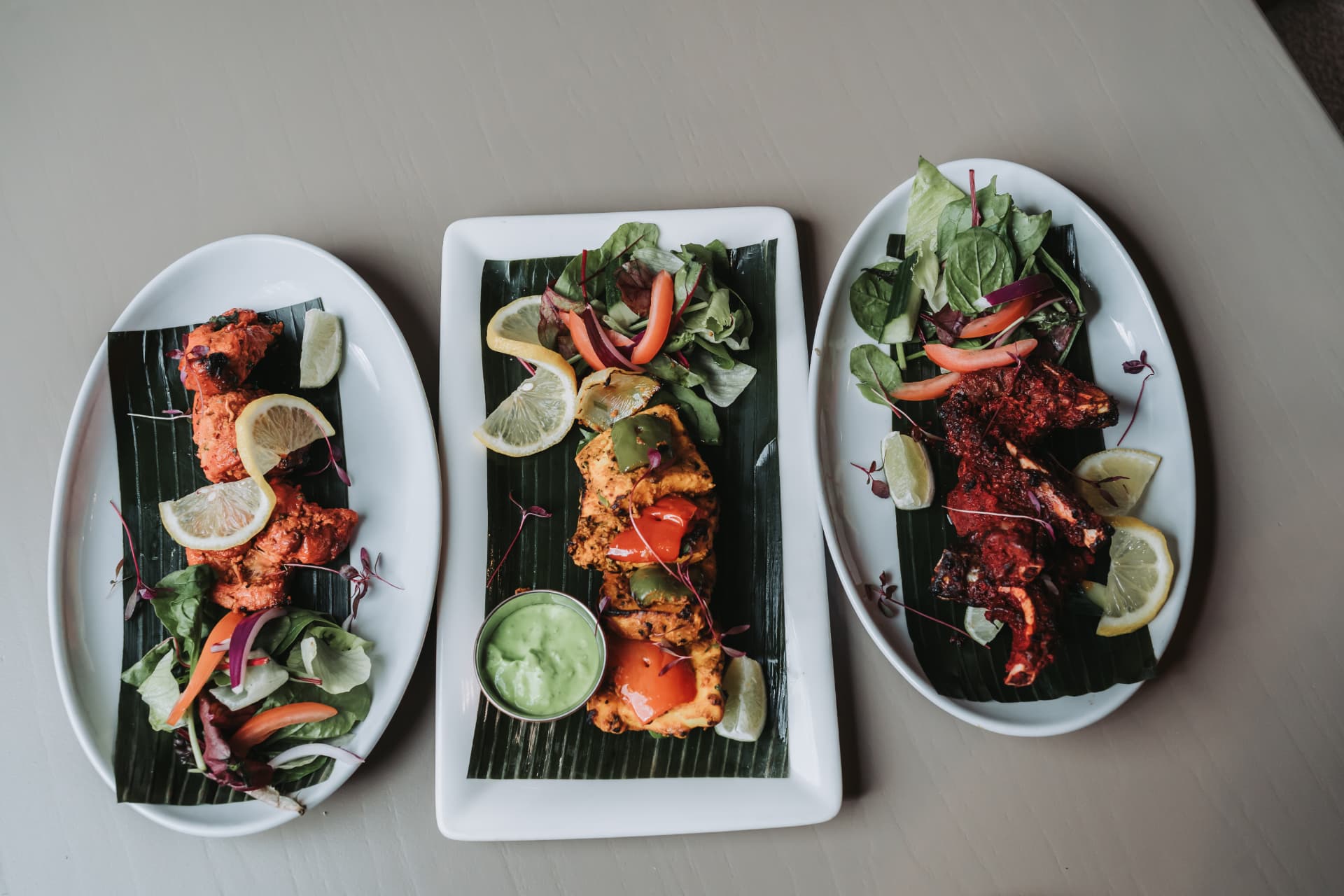 An overhead spread of three Anaya tandoori plates