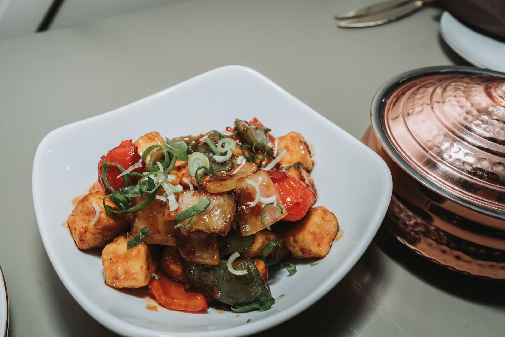 Paneer and pepper stir-fry served with a copper pot at Anaya