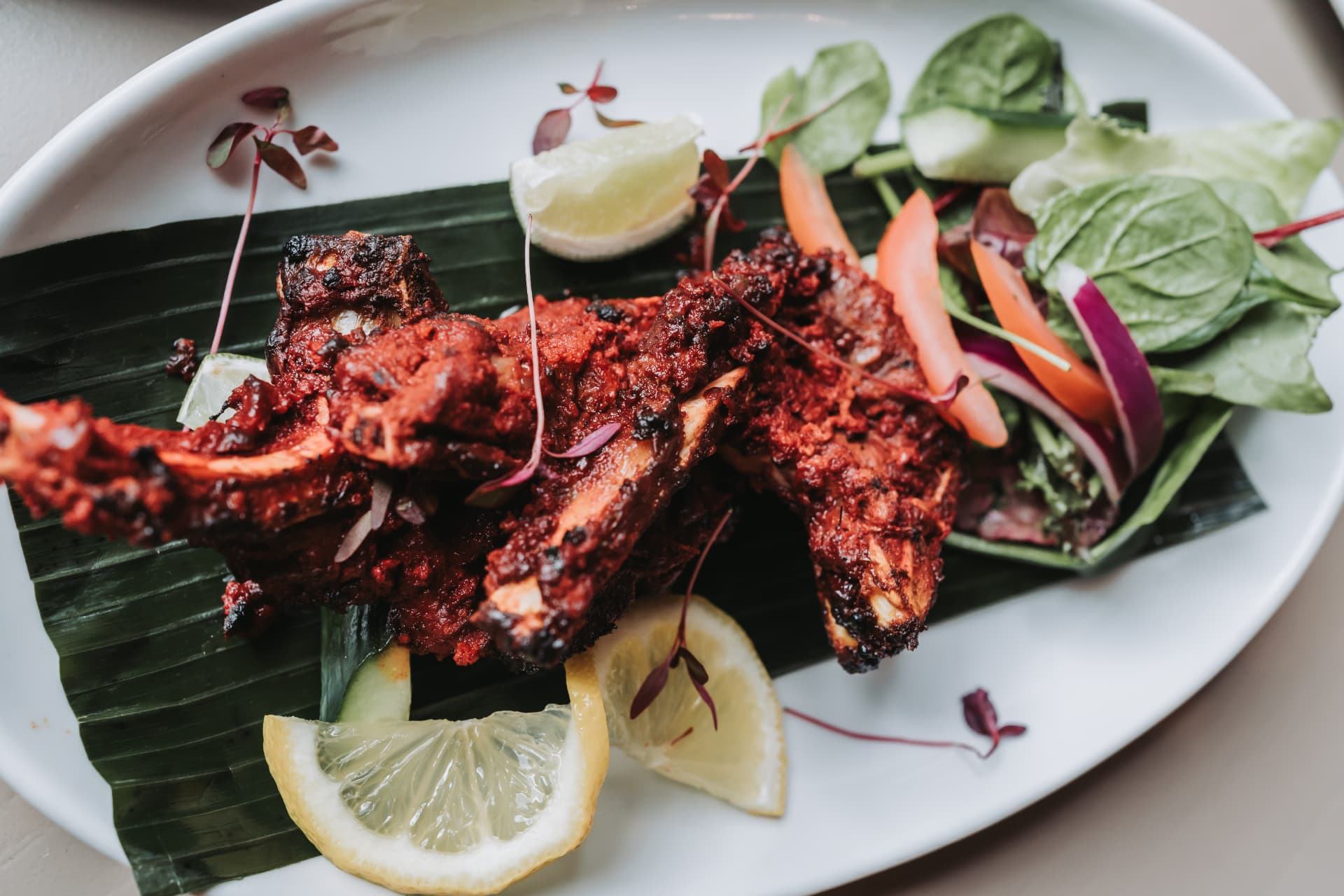 Tandoori dish served with salad and lemon at Anaya